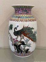 Full front view of porcelain vase showing peacock and floral decoration