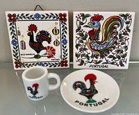 Front view of two rooster tiles, demitasse cup and saucer