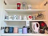 Overall lot in cabinet showing mugs, tumblers, kettle, teapot, infusers