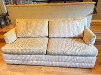 Front view of beige striped loveseat showing two seat and back cushions