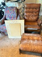 Group shot showing leather lounge chair, ottoman, paisley armchair, carved frame backing