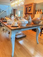 Overall view of the dining table with cabriole legs and brown plank top