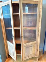 Full cabinet with doors partially open showing glass fronts and shelves