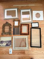 All eleven frames laid out on wooden floor showing styles, sizes and condition