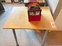 Top view of desk showing veneer surface, gray legs, red holder with maps