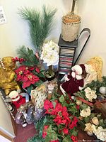 Overall view of assorted holiday decorations including garland, poinsettias, figures, wreath