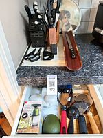 Overall lot showing knife block with knives, shears, sharpening stone, carving tray, and drawer of kitchen gadgets