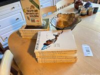 Books, boxed book, ceramic bowl, stoneware pieces on table