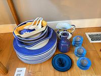 Stack of blue Spode dinner plates, assorted serving plates, white spoons, Italian pitcher, blue vase, three blue glass holders, small blue plate