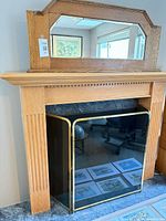 Full view of oak mantel, mirror, and brass screen