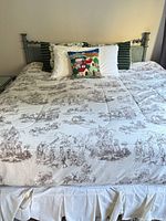 Queen bed setup showing mattress, box spring skirt and metal headboard