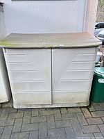 Closed Rubbermaid deck box against wall