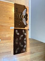 Both bee motif doormats side by side on floor