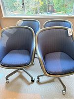 Four blue patterned swivel tub office chairs grouped together