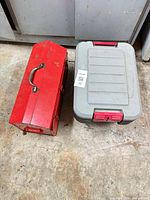 closed red steel toolbox and closed gray plastic toolbox