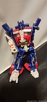 Front view of Optimus Prime figure seated, shows missing left arm and overall condition