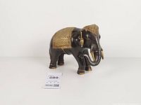 Left side view of brass elephant figurine showing gold overlay on back and feet