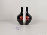 Front view of both vases facing outward showing red symbols