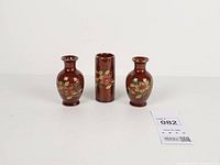 Front view of three brown ceramic vases showing shapes and floral design