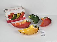 Four ceramic pepper bowls and original box displayed