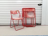 Five chairs visible, four stacked and one open, showing overall style and fading