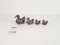 Four graduated pewter and brass duck trinket boxes in a row