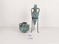 Amphora vase on metal stand next to jug, full view