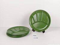 Stack of six green enamel divided plates with one displayed upright