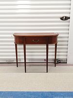 Front view of half-moon console table showing full form and legs