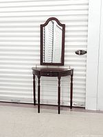 Console table with arched wall mirror mounted above, full view