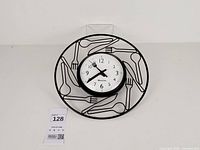 Full view of clock showing utensil frame and face