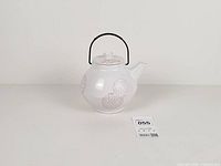 full view of teapot showing shape, pattern, handle, size reference tag 055