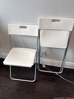 Front view of both white IKEA GUNDE folding chairs