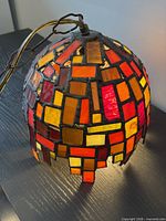 Side view of illuminated stained glass dome light showing colours and uneven edge