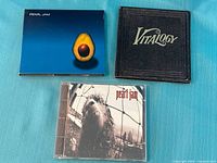 Front covers of three Pearl Jam albums: Avocado, Vitalogy, Vs.