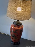 Full view of lamp illuminated, showing body, base, shade