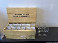 Open wooden box showing wine glasses in compartments