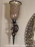 Full view of one sconce showing mosaic glass shade, metal arm and crystal drops