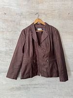 Full front view of brown Conrad C jacket on hanger