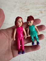 Front view of both figurines in hand for scale