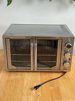 Front view showing double glass doors, wire rack inside and power cord