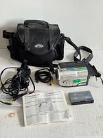 All items in lot laid out: camcorder, charger, battery, cassette, manuals, carry bag