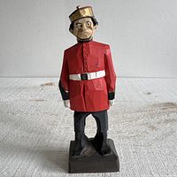 Front three-quarter view of carved wood bellhop on base