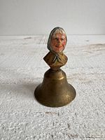 Front view showing complete bell with carved lady finial