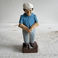 Front view of carved wood golfer figurine on base