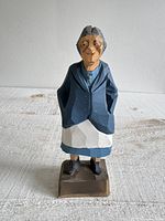 Full front view of carved grandma figurine standing on base