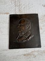 Full view of rectangular metal plaque with raised male profile