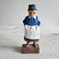 Front three-quarter view of carved wood woman figurine