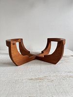 angled side view showing curved supports and teak grain