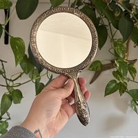 Front view of entire silver plated handheld mirror